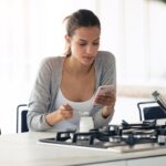 Woman eating while looking at smartphone