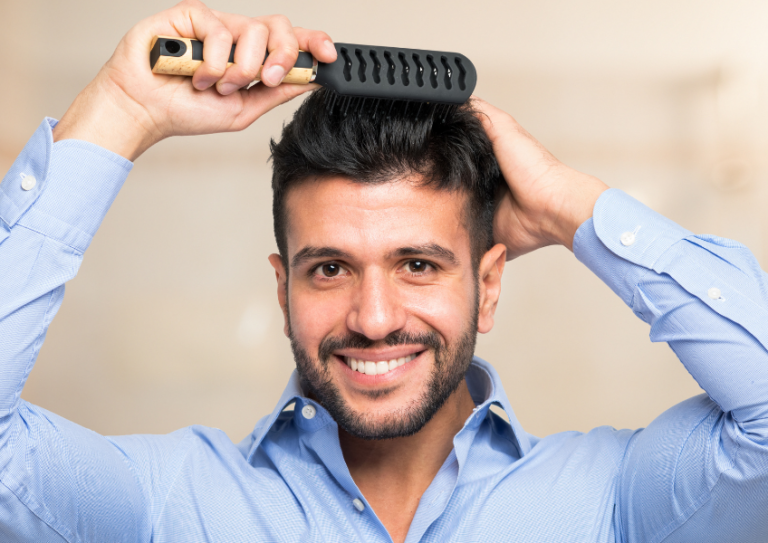 Happy man brushing full head of thick hair.