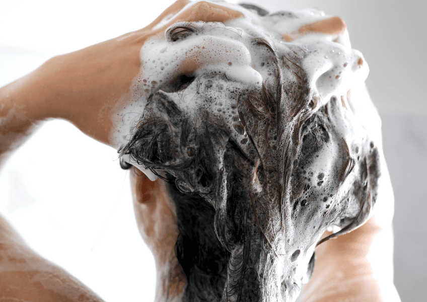 Washing hair with shampoo.