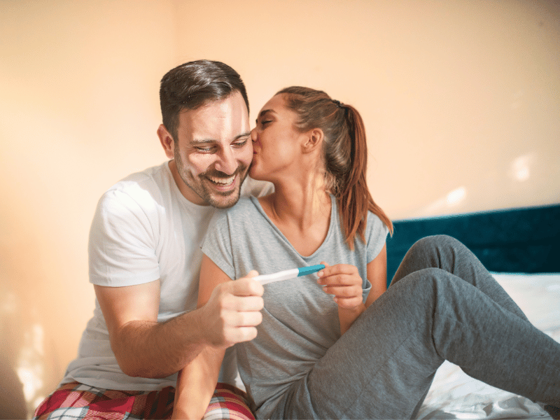 happy couple with positive pregnancy test