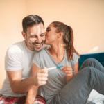 happy couple with positive pregnancy test
